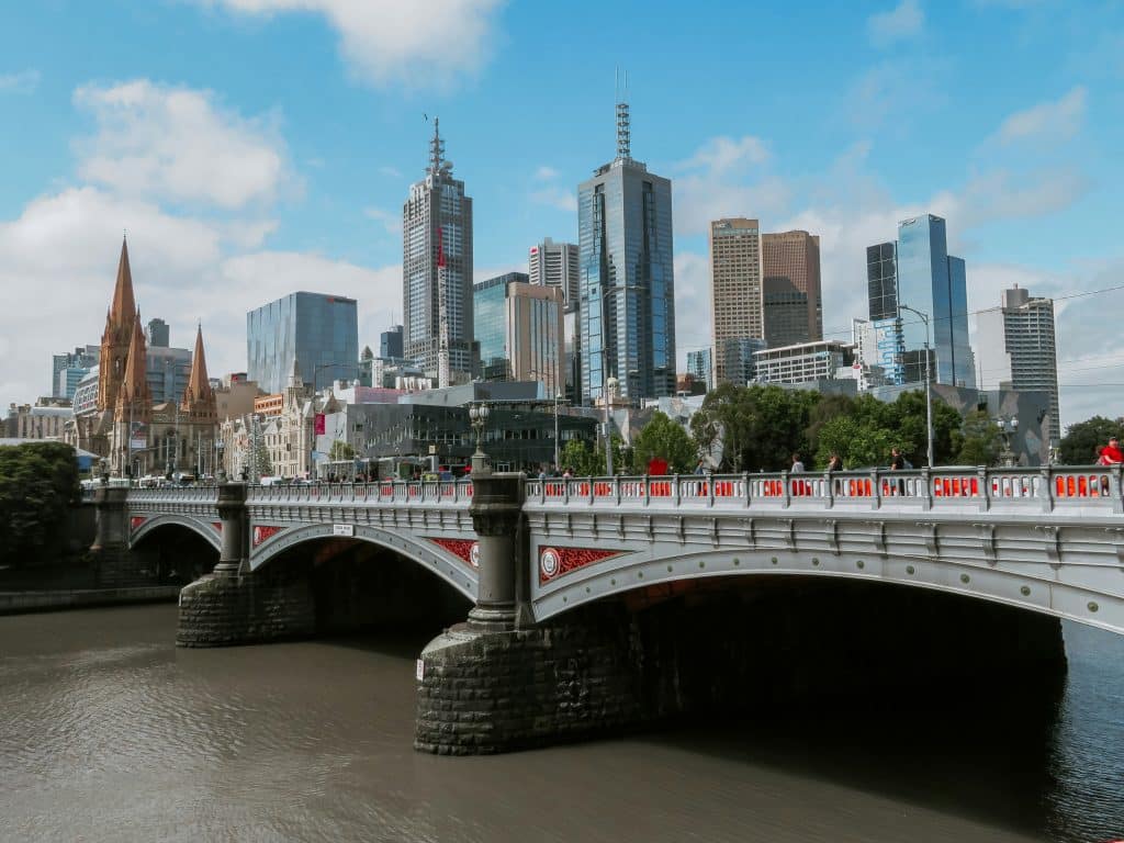 View of Melbourne city skyline with Princes Bridge crossing the Yarra River in the foreground.